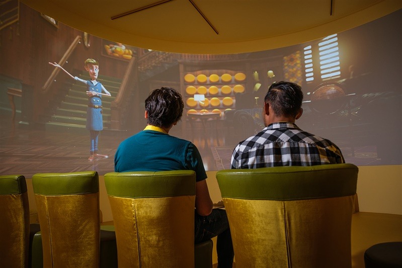 Twee bezoekers volgen een interactieve presentatie met kaasmeester Ralfie bij de Gouda Cheese Experience.